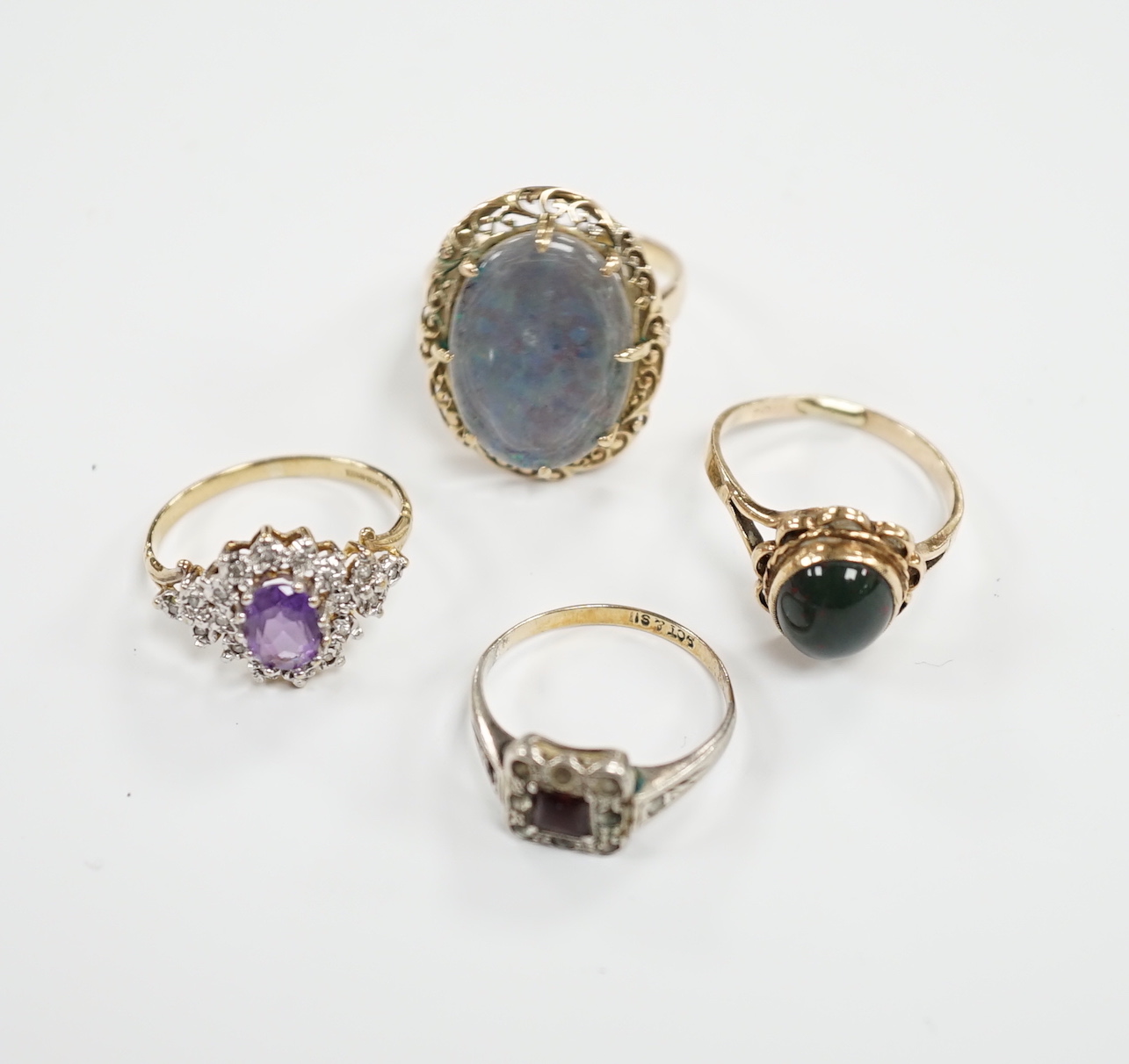 Two 9ct and gem set rings including cabochon bloodstone, a 14k and opal? doublet set ring and one other ring.